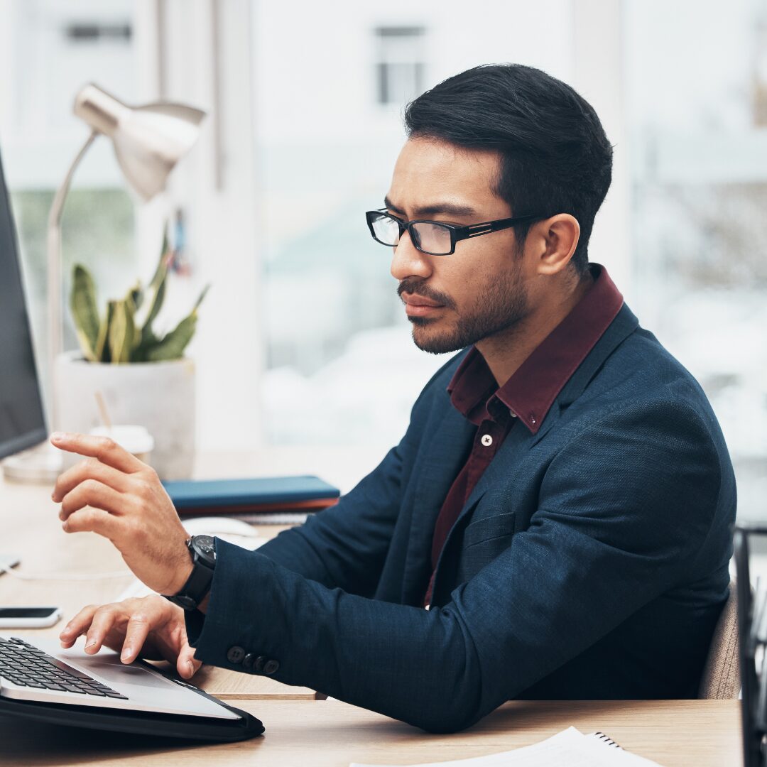 Mann im Anzug der vor dem Computer sitzt